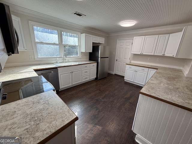 kitchen with dishwasher, freestanding refrigerator, light countertops, white cabinetry, and a sink