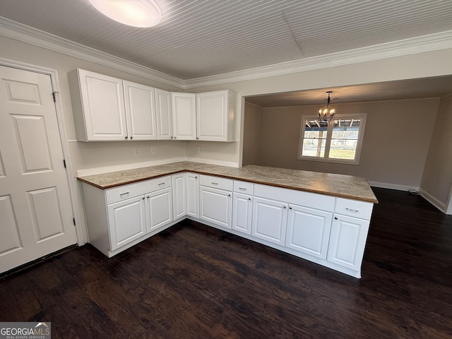 kitchen with white cabinets, decorative light fixtures, a peninsula, light countertops, and a chandelier