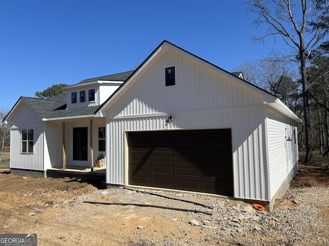 view of front of house with driveway, a shingled roof, and an attached garage