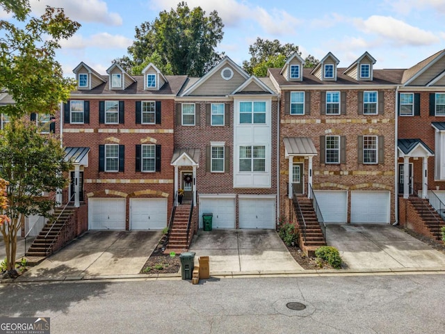 multi unit property featuring driveway, brick siding, and stairway