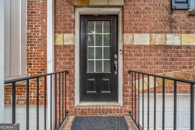 view of exterior entry featuring brick siding