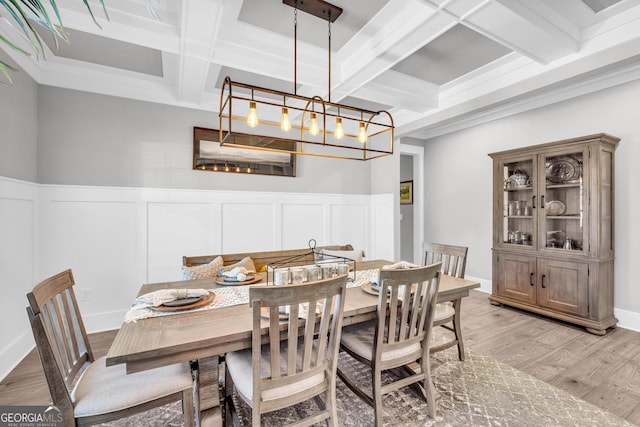 dining space featuring wainscoting, coffered ceiling, beam ceiling, and light wood-style floors