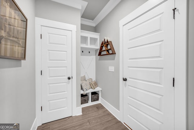 mudroom with ornamental molding, wood finished floors, and baseboards