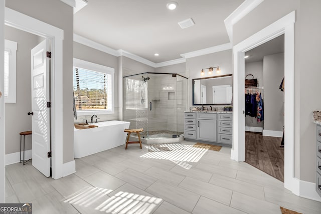 full bathroom with ornamental molding, a soaking tub, vanity, and a shower stall