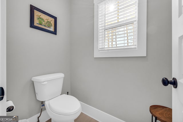 bathroom featuring toilet and baseboards