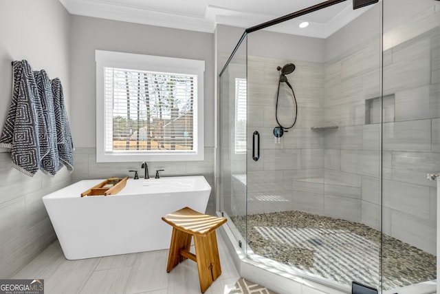 full bathroom featuring a stall shower, tile walls, ornamental molding, and a freestanding bath