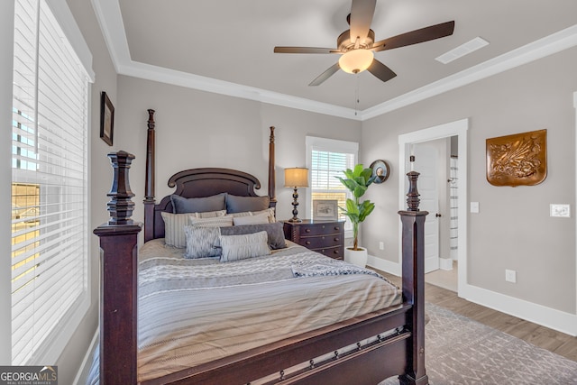 bedroom featuring ceiling fan, wood finished floors, visible vents, baseboards, and crown molding