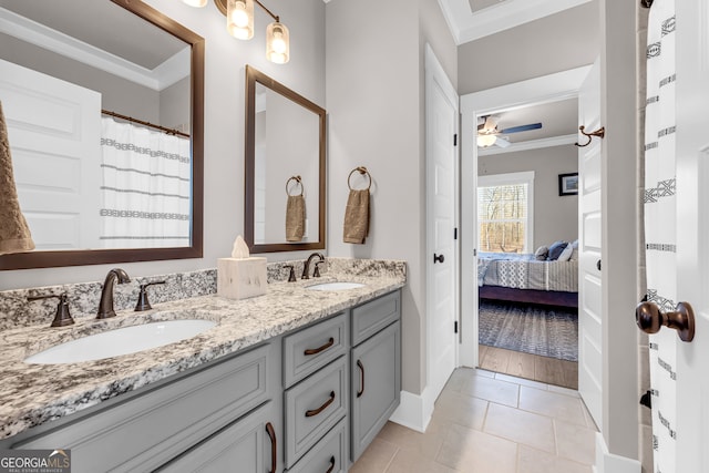 ensuite bathroom featuring ceiling fan, connected bathroom, ornamental molding, and a sink