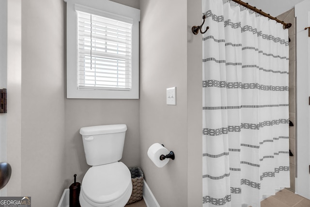 bathroom with toilet and curtained shower