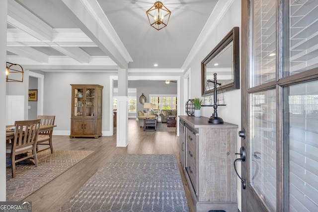 entrance foyer featuring beam ceiling, ornamental molding, wood finished floors, coffered ceiling, and baseboards