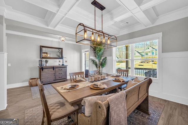 dining room with a wealth of natural light, visible vents, coffered ceiling, and wood finished floors