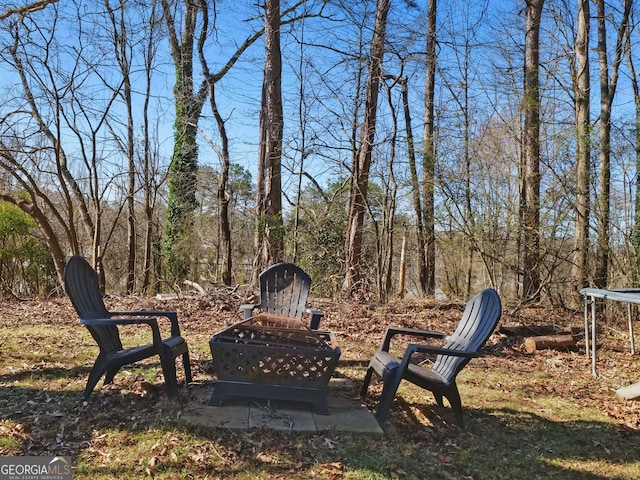 view of yard featuring a trampoline and an outdoor fire pit