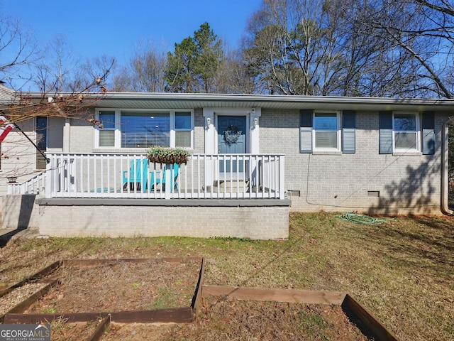 view of front of home featuring crawl space, a front lawn, and brick siding