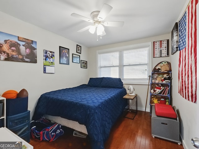 bedroom with a ceiling fan, baseboards, and dark wood-style flooring