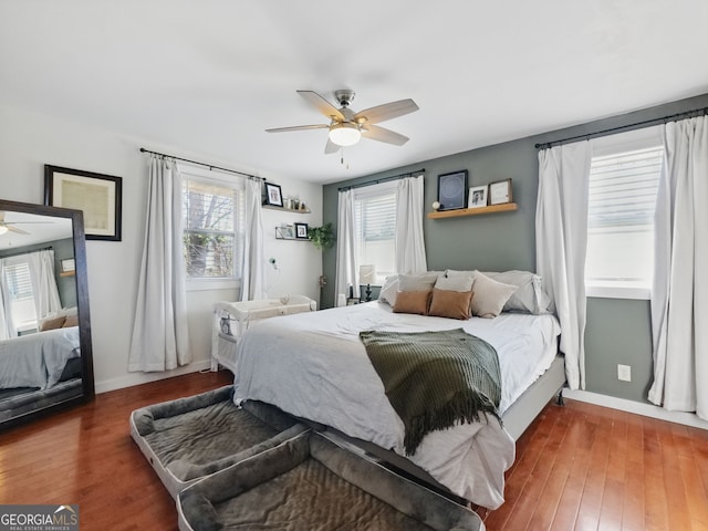 bedroom featuring a ceiling fan, baseboards, and wood finished floors