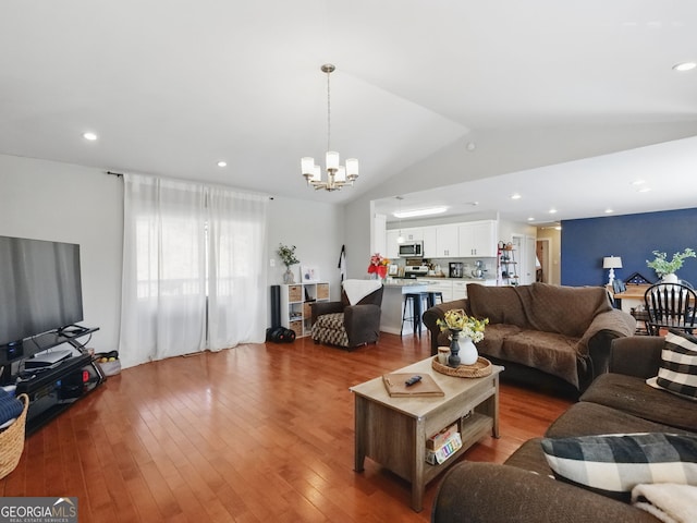 living area with light wood-type flooring, an inviting chandelier, recessed lighting, and lofted ceiling