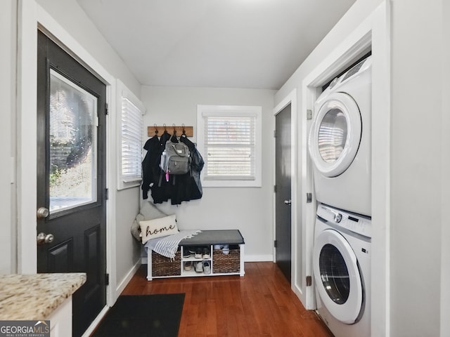 clothes washing area featuring a wealth of natural light, stacked washer / dryer, laundry area, and dark wood-style floors