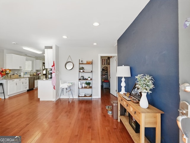 living room with baseboards, wood finished floors, and recessed lighting