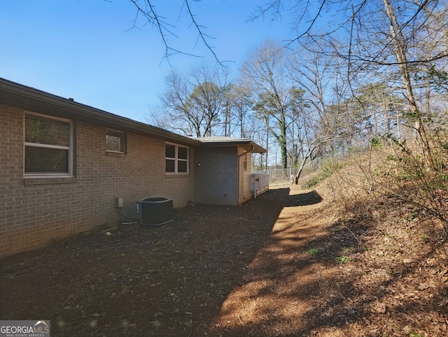 view of home's exterior with cooling unit and brick siding