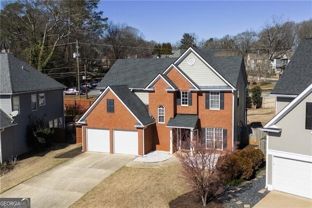 traditional-style home featuring driveway, roof with shingles, fence, and brick siding