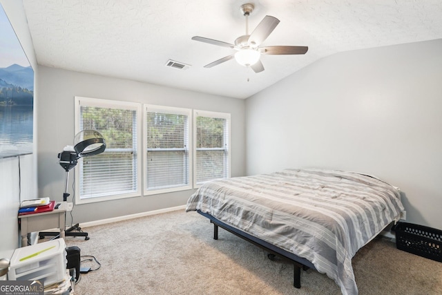 bedroom with carpet floors, visible vents, vaulted ceiling, a textured ceiling, and baseboards