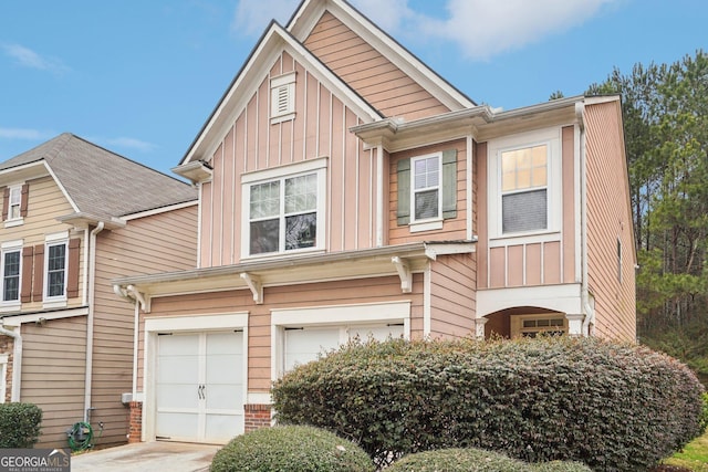 view of property featuring board and batten siding, driveway, and a garage