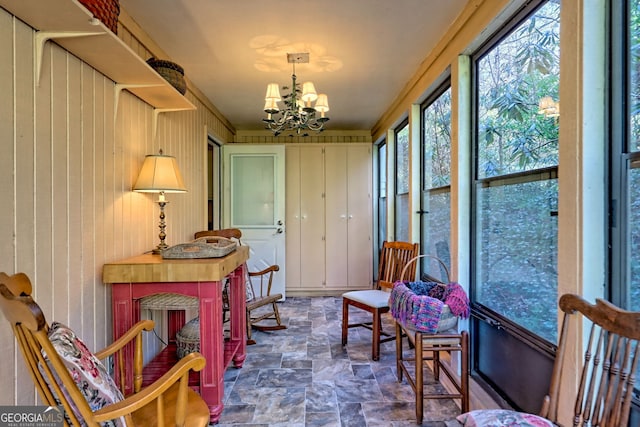 sunroom / solarium with a notable chandelier