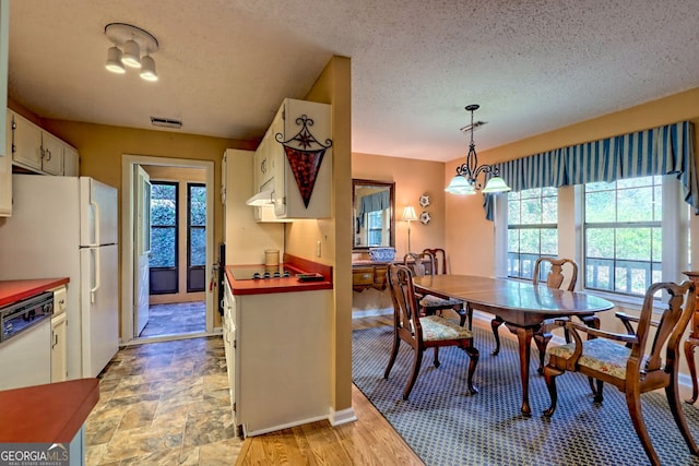 dining space featuring visible vents, baseboards, and a textured ceiling