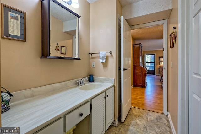 bathroom with tile patterned floors, baseboards, and vanity