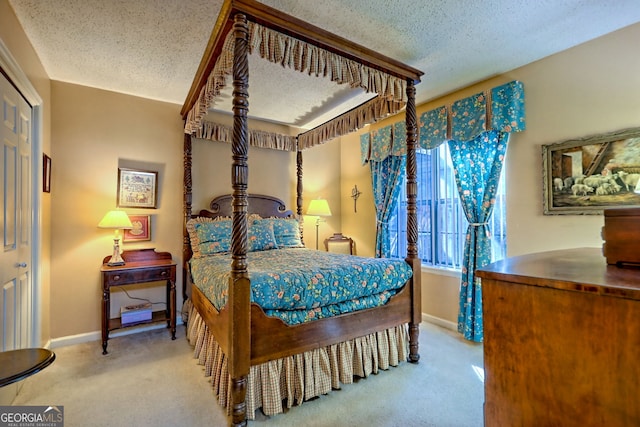 bedroom featuring light carpet, a textured ceiling, and baseboards