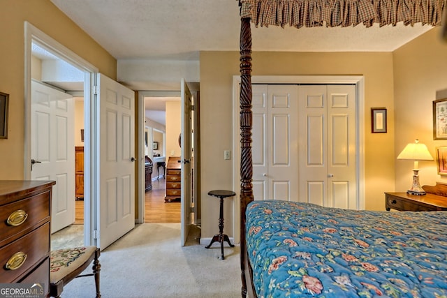 bedroom featuring a closet, light carpet, and a textured ceiling