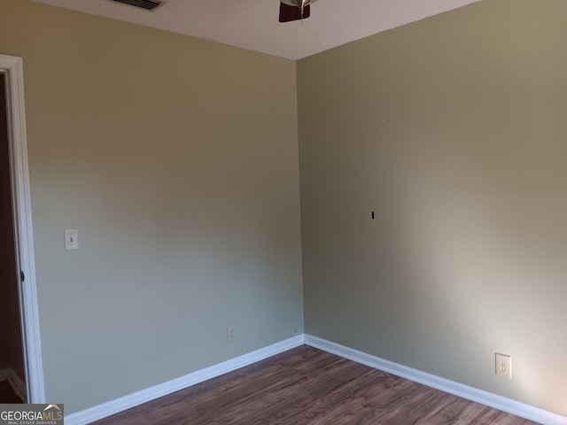 spare room with dark wood-style floors, ceiling fan, and baseboards