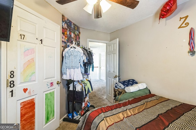 carpeted bedroom with ceiling fan and a textured ceiling