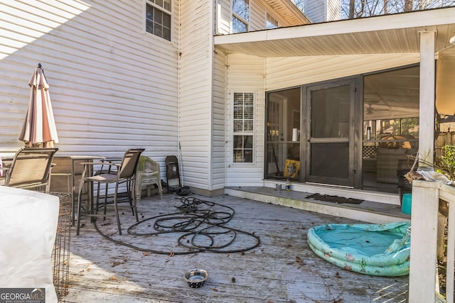 view of patio featuring a deck and a sunroom