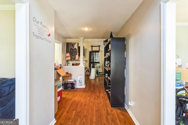 hall with a textured ceiling and wood finished floors