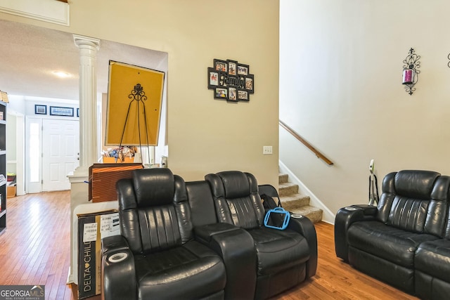 home theater room with ornate columns and wood finished floors