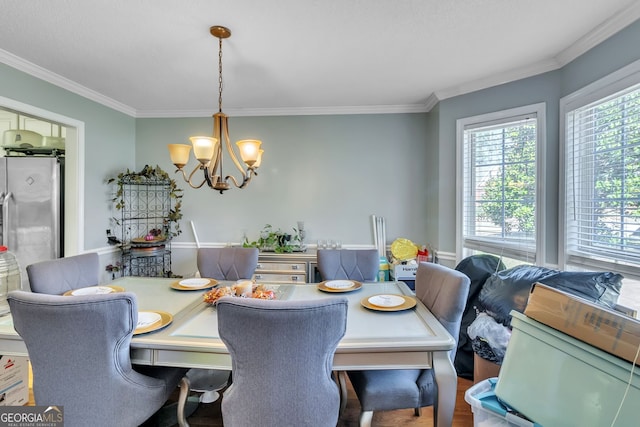 dining space featuring a chandelier and crown molding