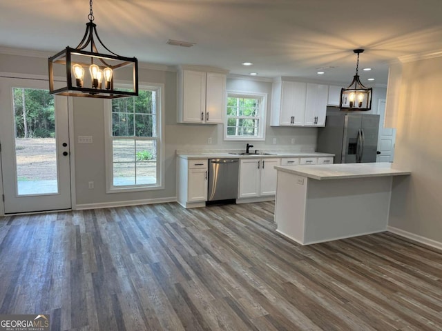 kitchen featuring pendant lighting, light countertops, white cabinetry, and stainless steel appliances