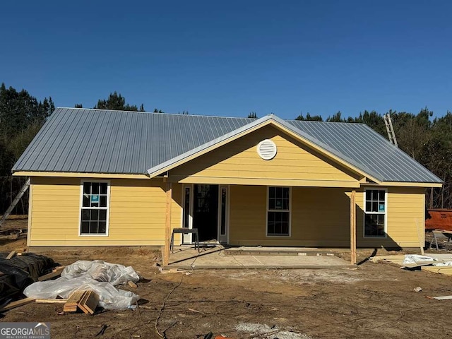 view of front of house featuring metal roof and a patio area