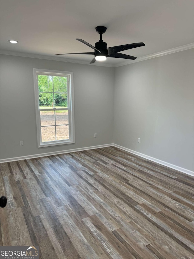 spare room with baseboards, wood finished floors, a ceiling fan, and crown molding