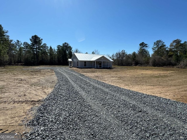 view of front of property featuring gravel driveway and metal roof