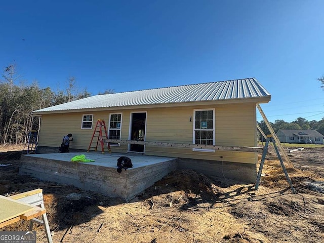 view of front of property featuring metal roof and a patio