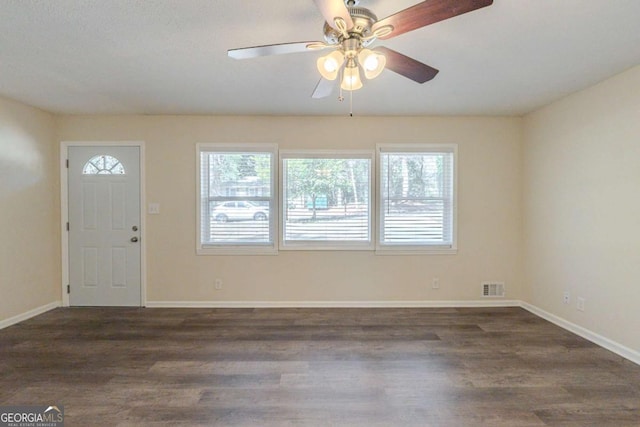 foyer featuring dark wood-style floors, visible vents, ceiling fan, and baseboards