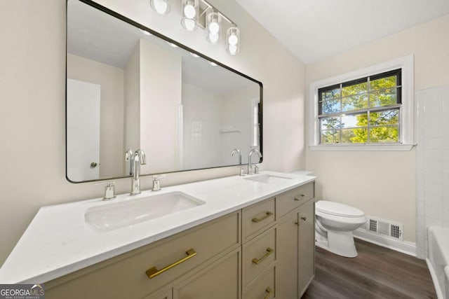 full bathroom with visible vents, a sink, toilet, and double vanity