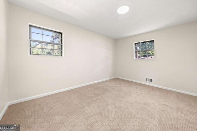 empty room with light carpet, baseboards, and visible vents