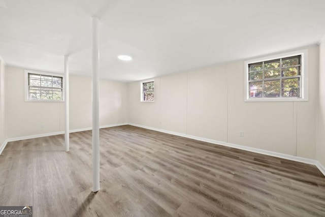 basement with baseboards and wood finished floors