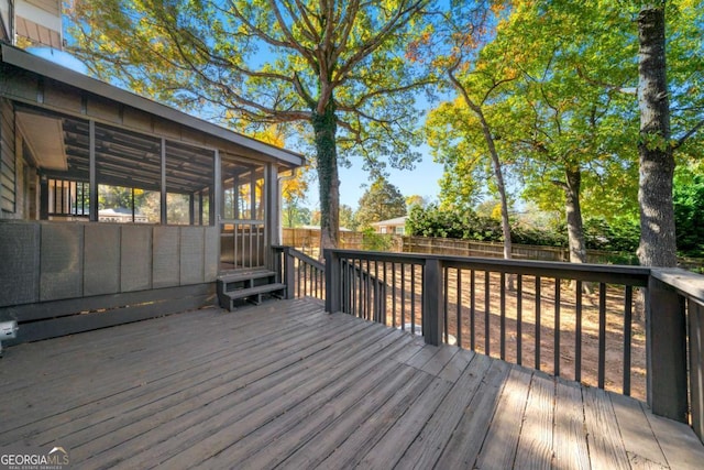 deck with a sunroom and a fenced backyard