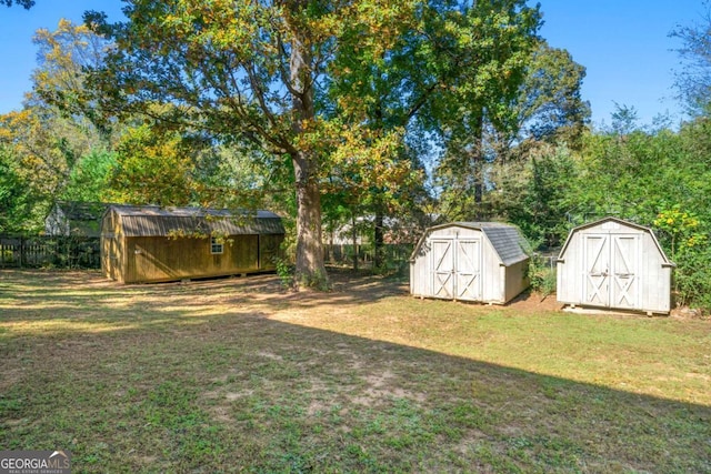 view of yard featuring an outbuilding, a shed, and fence