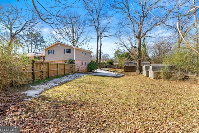 view of yard with fence private yard, a shed, and an outdoor structure