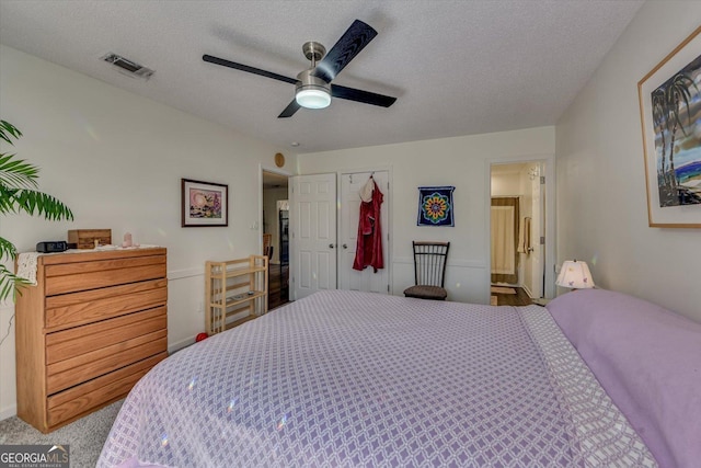 bedroom with a textured ceiling, carpet, visible vents, and a ceiling fan